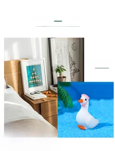 Miniature white swan figurine with a pink hat in a cozy bedroom nightstand setting