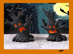 Detail macro shot of evil tree monster resin figurines with glowing pumpkin faces