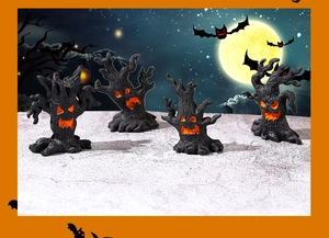 Set of four Halloween tree monster resin ornaments with glowing orange faces in moonlight