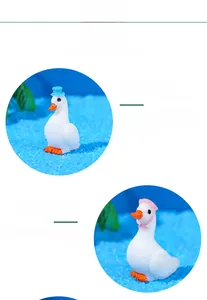 Detailed view of miniature resin swans wearing blue sun hats and pink tied bonnets