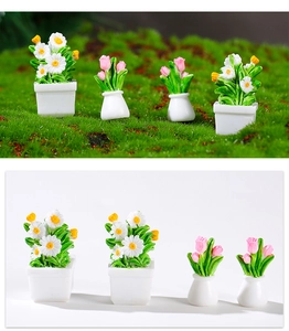 Macro detail of dollhouse miniature daisies and pink tulips in small white ceramic vases