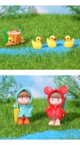 Miniature garden set with raincoated couple dolls, yellow ducks and a resin tree stump