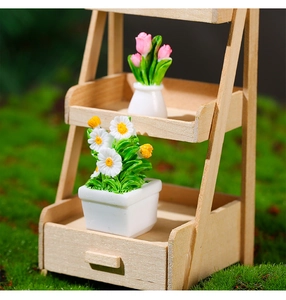 Close-up of miniature dollhouse flower pots on a wooden stand with a mossy background