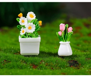 Macro detail of miniature dollhouse potted white daisies and pink tulips on moss
