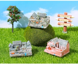 Detailed macro view of three miniature Chinese courtyard houses on a lush moss lawn