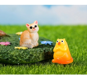 Macro-opname van miniatuurfiguren van hars van een kat en hamster op een tuinstandaard