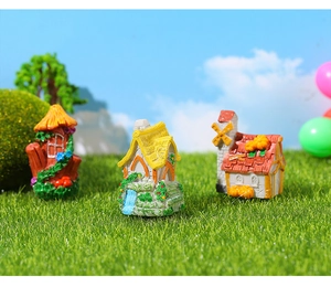 Vue détaillée de maisons de jardin de fées en résine avec textures de pierre sur l'herbe