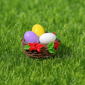 Miniature Easter resin nest with colorful eggs and red flowers on green grass