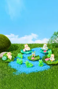 Detailed resin frog figurines set on artificial turf and blue sand landscape scene