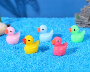 Detailed view of five colorful resin ducks on blue sand for moss micro landscapes