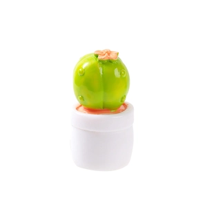 Miniature dollhouse cactus plant in white pot with small pink flower on white background