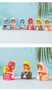 Detailed view of six colorful cartoon girl figurines sitting on books playing video games