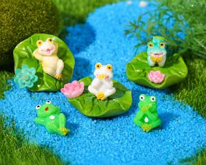 Detail view of five miniature resin frog figurines with lotus leaves for aquarium decor