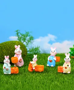 Nahaufnahme von fünf bunten Hasenfiguren aus Harz in einer Miniaturgartenszene