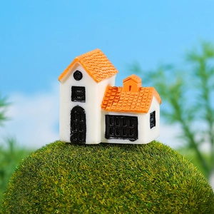 Miniature European house model with orange roof on green moss for DIY micro landscapes