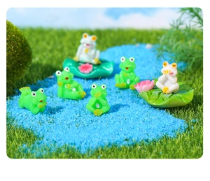 Miniature frog figurines set in resin featuring diverse poses and pink lotus leaf bases