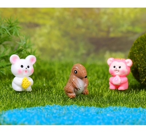 Miniature resin animal figurines including a mouse, pangolin, and bear in a moss landscape