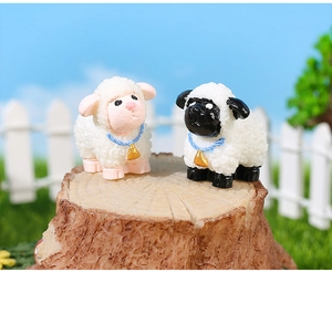 Macro shot of cute resin sheep figurines with blue ropes and gold bells for micro landscapes