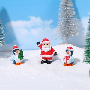 Miniatur Weihnachtsfiguren aus Harz mit Weihnachtsmann und Pinguinen auf Kunstschnee
