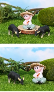 Nahaufnahme der Märchengarten-Figur mit Hirtenjunge und Wasserbüffel auf grünem Moos