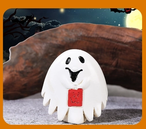Close-up of Halloween ghost resin figurine holding a red treat bag for spooky decor