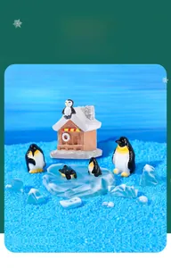 Detailed view of miniature resin penguins and igloo figurines on ice base