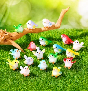 Détail de figurines d'oiseaux miniatures en résine colorée pour décor de jardin