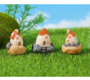 Detailed view of three miniature resin houses with orange roofs for garden landscaping