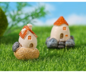 Macro detail of miniature resin house with orange roof and stone textured base for decor