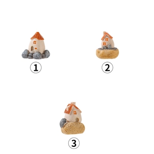 Three miniature resin fairy garden houses with orange roofs and detailed stone bases