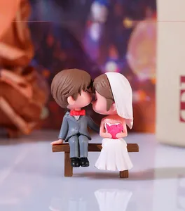 Close-up of cute cartoon wedding couple figurines sitting on a bench for micro landscape