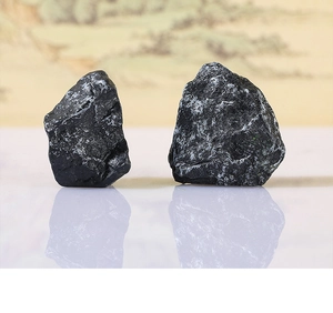Macro view of two irregular black landscape stones with natural rock texture and reflections