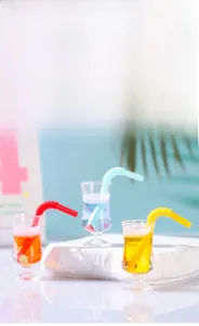 Détail macro de gobelets à jus miniatures avec liquides colorés et pailles pour travaux DIY
