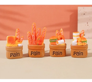 Macro detail of miniature resin bread baskets featuring baguette and croissant textured models