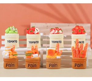 Detailed macro view of miniature resin food baskets with tomato and bread on white bench