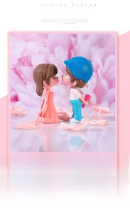 Close-up of romantic resin couple figurines featuring a girl in dress and boy with flowers