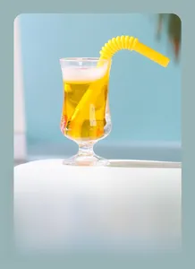 Détail macro d'un pendentif gobelet à jus en résine avec liquide jaune et glaçons