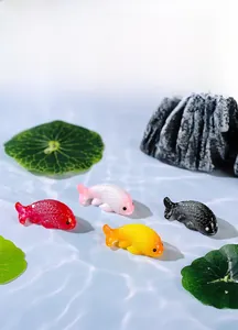 Detailed close-up of colorful resin goldfish miniatures on a blue water-like surface