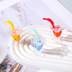 Miniaturas de vasos de zumo de frutas con lentejuelas y pajitas en bandeja blanca