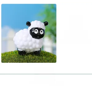 Miniature resin sheep figurine with white textured wool and black face on green grass