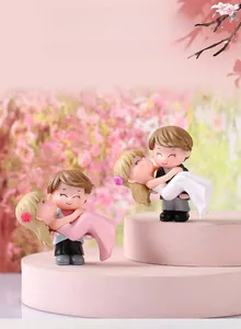 Close-up of PVC wedding couple figurines showing groom holding bride for DIY decor