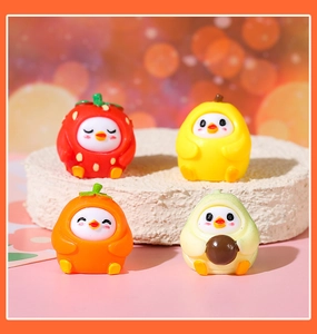 Detailed view of four colorful resin fruit bird figurines on a white display stand