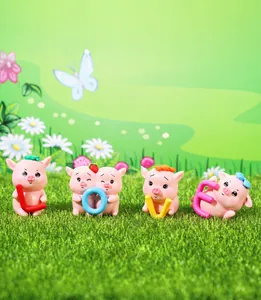 Set of four cute pink resin pigs holding LOVE letters on miniature grass landscape