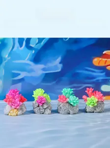 Close-up of four colorful resin succulent miniatures on gray stone bases for terrariums