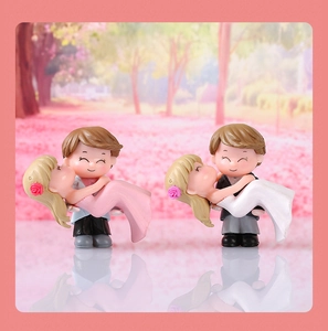 Close-up of miniature couple figurines in romantic embrace for micro landscape decor