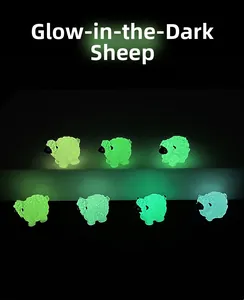 Lot de sept figurines de moutons lumineux en résine colorée sur fond noir profond