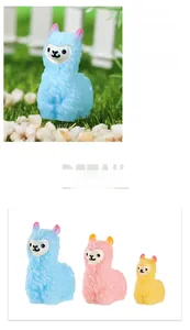 Macro detail of three colorful miniature resin alpacas for garden decoration