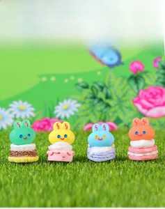 Detailed view of four colorful bunny cake resin figurines on green grass turf