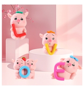 Detail of four cute pink resin pigs holding LOVE letters for desktop or car decor