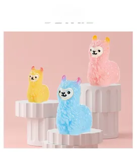 Detailed view of colorful resin alpaca figurines on white pedestals in a studio setting